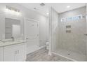 Bathroom boasts a large walk-in shower, white vanity with quartz countertop and gray tile floor at 5595 Dinkler Ave., Loris, SC 29569