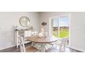 Bright dining area with a round table, white chairs, and sliding glass doors leading to the backyard at 552 Duvall St., Longs, SC 29568