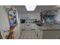 Condo kitchen featuring granite countertops, white cabinets, and mural at 2711 S Ocean Blvd. # 1937, North Myrtle Beach, SC 29582