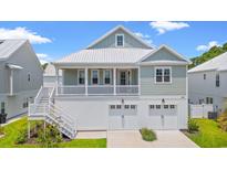 Two-story house with a light gray exterior, two-car garage, and a front porch at 454 Wilcox Ave., Murrells Inlet, SC 29576