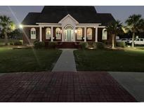 Brick home with a large front yard, walkway and landscaping at night at 420 Maple Ave., Johnsonville, SC 29555