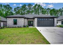 Modern craftsman style home with gray brick exterior, dark gray garage door, and a well-manicured lawn at 329 Spinney Dr., Little River, SC 29566