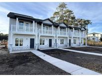 Three-unit townhome building, gray siding, stone accents, and white railings at 801 Rebecca Ln. # 7A, Myrtle Beach, SC 29577