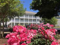 Building exterior surrounded by beautiful rose bushes at 4655 Wild Iris Dr. # 203, Myrtle Beach, SC 29577