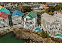 Aerial view of a three-story house with private pool near the water at 2502 Pointe Marsh Ln., North Myrtle Beach, SC 29582