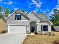 Two-story home with gray siding, white garage door, and stone accents at 370 Long Meadow Dr., Loris, SC 29569