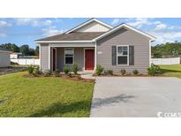 Gray house with red door, landscaping, and a concrete driveway at 154 Cambridge Dr., Tabor City, NC 28463