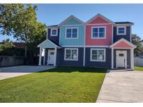 Two-story duplex with gray, teal, and pink exterior and small lawn at 503 30Th Ave. N, Myrtle Beach, SC 29577