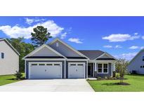 Curb appeal abounds with this charming one-story home showcasing a two-car garage and well-manicured lawn at 120 Little Cedar Dr., Loris, SC 29569