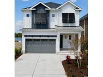 Two-story home with gray garage door and shutters at 829 Crystal Water Way, Myrtle Beach, SC 29579