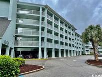 This light teal building features multiple balconies and parking at 14290 Ocean Highway # 111, Pawleys Island, SC 29585