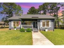 Gray house with white shutters, front porch, and landscaped yard at 1302 Conifer Ct., Murrells Inlet, SC 29576