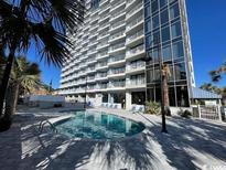 Refreshing community pool with surrounding palm trees at 5511 N Ocean Blvd. # 1106, Myrtle Beach, SC 29577