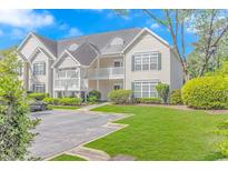 Two-story condo building with light beige siding and green landscaping at 100 Scotch Broom Dr. # 204, Little River, SC 29566