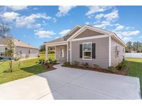 Gray house with front yard and driveway at 1910 Whispering Pine St., Ocean Isle Beach, NC 28469