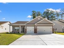 Two-car garage, neutral colors, and landscaping at 292 Hayloft Circle, Conway, SC 29526