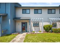 Front view of a light blue and white townhouse with a landscaped yard at 775 Plantation Dr. # 88, Little River, SC 29566