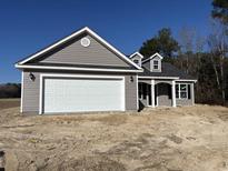 New construction home with gray siding, white garage door, and landscaping at 7052 Shady Grove Rd., Conway, SC 29527