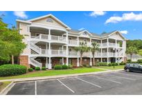 Three-story building with multiple balconies, ample parking, and landscaping at 6015 Catalina Dr. # 421, North Myrtle Beach, SC 29582