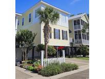 Two-story beach house with a yellow exterior, white trim, and black shutters at 5226 Highway 17 Business, Murrells Inlet, SC 29576