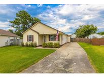 House exterior featuring a yellow vinyl-sided home, landscaping, and a driveway at 8089 Bark Ct., Murrells Inlet, SC 29576