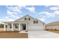 Two story home with gray siding, white trim, and a two car garage at 3869 Lady Bug Dr., Shallotte, NC 28470