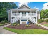 Two-story condo building with white railings and stairs, landscaped grounds at 629 Blue Stem Dr. # 74D, Pawleys Island, SC 29585