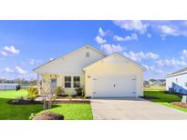 Beautiful yellow and white exterior of a new home with a two-car garage and landscaping at 3059 Deerberry Place, Longs, SC 29568