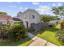 Two-story townhome with red door, landscaping, and fenced backyard at 800 9Th Ave. S # T-4, North Myrtle Beach, SC 29582