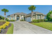 Green house with driveway, landscaping, and palm trees at 2000 Hideaway Point, Myrtle Beach, SC 29579