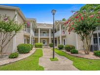 Two-story building with landscaping, offering a welcoming entrance at 1301 Sweetwater Blvd. # 1301, Murrells Inlet, SC 29576