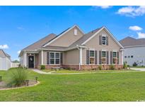 Tan house with a green lawn and landscaping at 5188 Country Pine Dr., Myrtle Beach, SC 29579