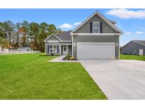 Gray house with white garage door and green lawn at 110 Brian Oaks Trail, Aynor, SC 29511