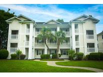 Three-story condo building with attractive landscaping and a walkway at 533 White River Dr. # 18D, Myrtle Beach, SC 29579