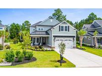 Two-story home with light green siding, a metal roof, and a landscaped lawn at 2056 Summer Rose Ln., Myrtle Beach, SC 29579