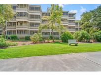 Building exterior showcasing landscaping and a relaxing bench at 415 Ocean Creek Dr. # 2333, Myrtle Beach, SC 29572