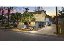 Two-story beach house with palm trees, a paved driveway, and a landscaped yard at 605 36Th Ave. S, North Myrtle Beach, SC 29582