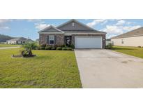 Brick ranch home with a large driveway and landscaped yard at 197 Golden Bear Circle, Longs, SC 29568