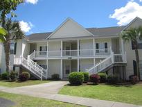 Two-story condo building with white siding and stairs at 5011 Harvest Dr. # 203, Myrtle Beach, SC 29579