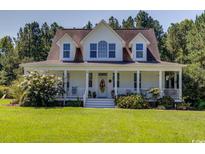 Two-story home with white siding, brown roof, and a large front porch at 5356 Hamps Rd., Nichols, SC 29581