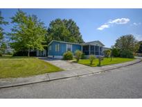 Blue house with a screened porch and landscaped yard at 1119 Blue Ridge Trail, North Myrtle Beach, SC 29582