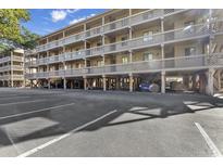 View of the exterior of a multi-story condo building with parking spaces in front at 210 Maison Dr. # K 202, Myrtle Beach, SC 29572