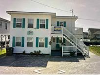Two-story beach house with teal accents and a staircase at 329 54Th Ave. N, North Myrtle Beach, SC 29582