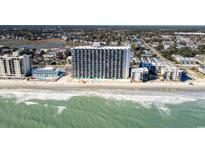 Aerial view of oceanfront high rise building with beach and surrounding neighborhood at 1210 N Waccamaw Dr. # 402, Garden City Beach, SC 29576