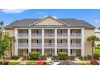 Two-story condo building with columns, balconies, and ample parking at 631 Woodmoor Dr. # 303, Murrells Inlet, SC 29576