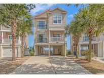 Two story home with attached garage, elevated with palm trees at 2406 Pointe Marsh Ln., North Myrtle Beach, SC 29582