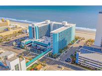 Aerial view of a large teal building near the beach with parking and a walkway at 1501 S Ocean Blvd. # 1235, Myrtle Beach, SC 29577