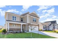 Two-story house with beige siding, stone accents, and a two-car garage at 357 Glacier Way, Conway, SC 29526