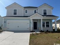 Two-story home with light blue and gray siding, a white door, and a two-car garage at 2409 Grand Meadow Dr., Longs, SC 29568