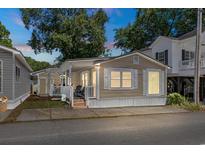 Tan colored house with white trim, front porch, and small yard at 6001 - 1824 S Kings Hwy., Myrtle Beach, SC 29575